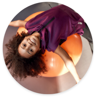 Girl on an exercise ball during an intermediate recreation class hosted by Rad Gymnastics.
